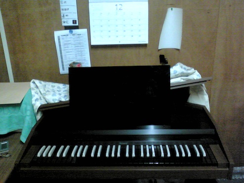 電子チェンバロ上部の蓋を開け、黒色のプラスチック板を立て掛けた状態